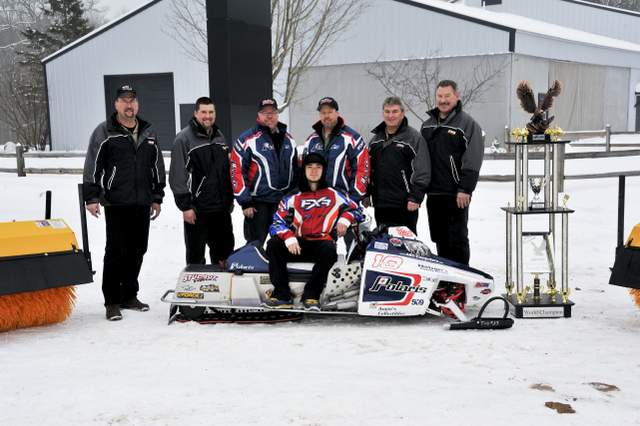 After winning the 2012 AMSOIL World Championship Snowmobile Derby, Nick Van Strydonk (seated on snowmobile) recently visited the Case Customer Center in Tomahawk, Wis. Posing with the champion and his trophy are (from left) Robb Coenen, Case product promotion specialist;  Jeff Jablonski, Case product promotion specialist;  Allen Van Strydonk, owner of Erv’s Sale & Service Tomahawk; Jim Van Strydonk,  owner of Van Strydonk Construction; Russ Wadzinski, general manager, Case Customer Center; and Steve Cudd,  Case product promotion specialist. 