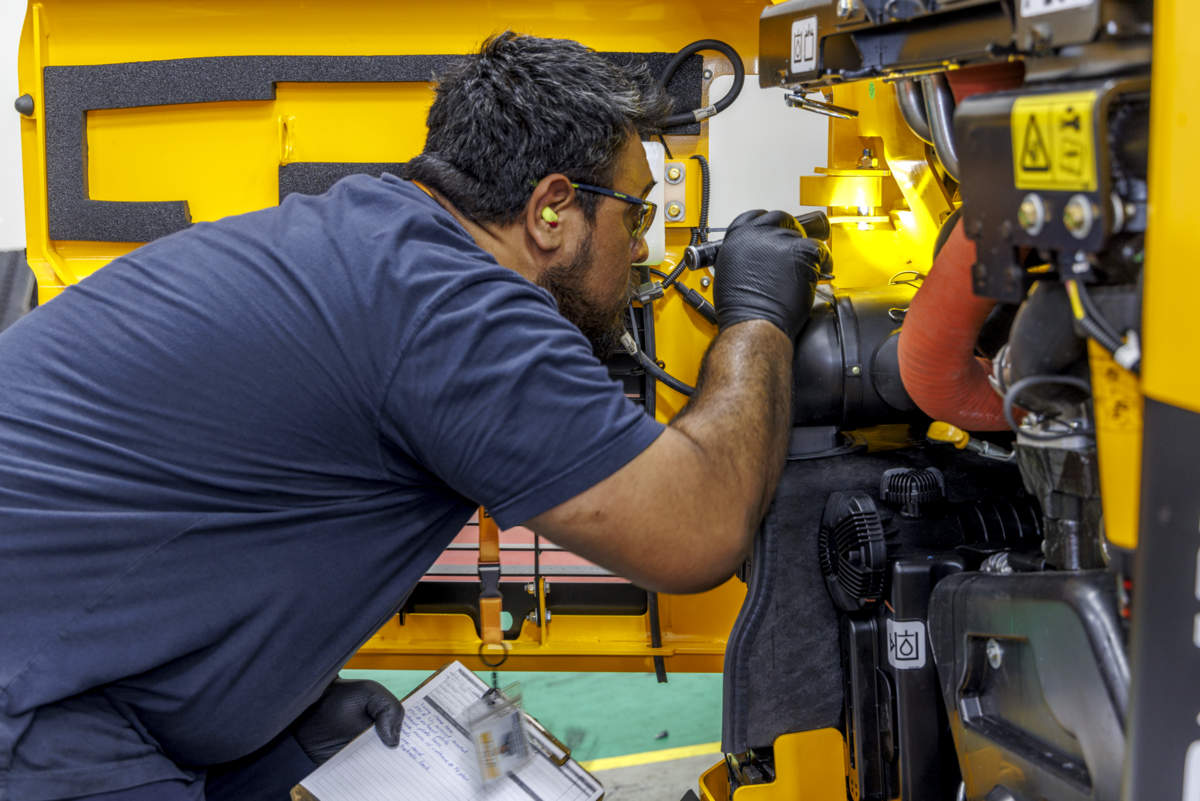 JCB maintenance mechanic technician looking at the engine JCB loader