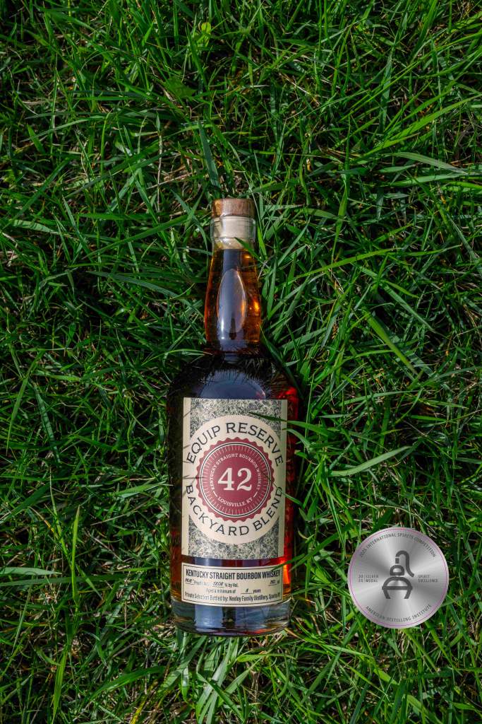 Equip Reserve 42: Backyard Blend bottle in the grass Equip Expo bourbon