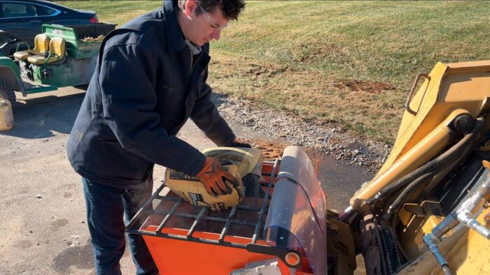 EZG mobile mixer attachment man loading cement into hopper