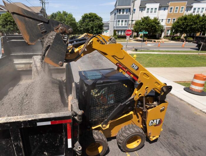 Caterpillar 250 Next GEneration skid steer dumping into a dump truck