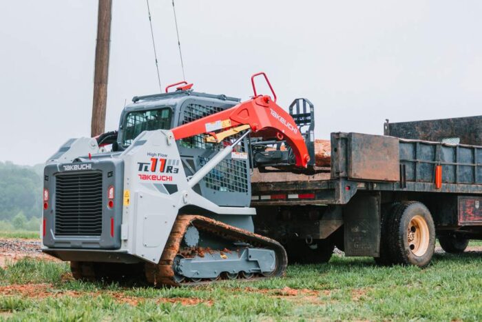 Takeuchi TL11R3 compact track loader with pallet forks loading a truck