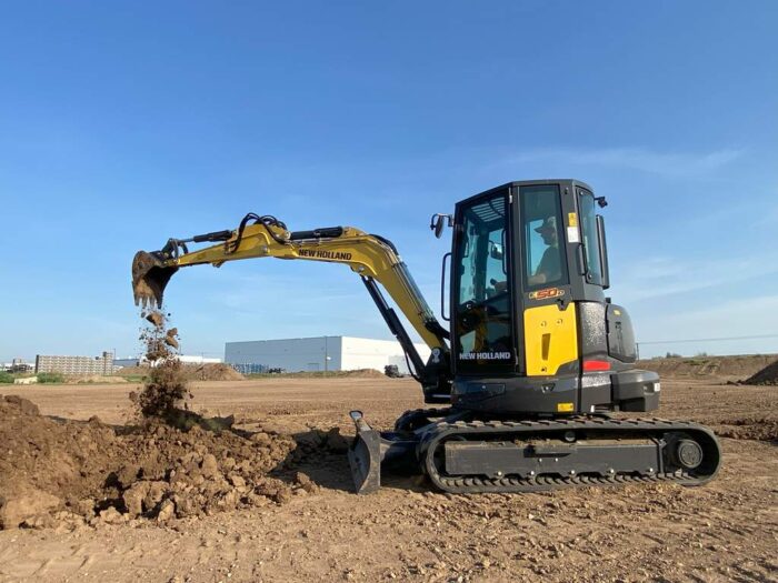 New Holland E50D mini excavator digging in the dirt 