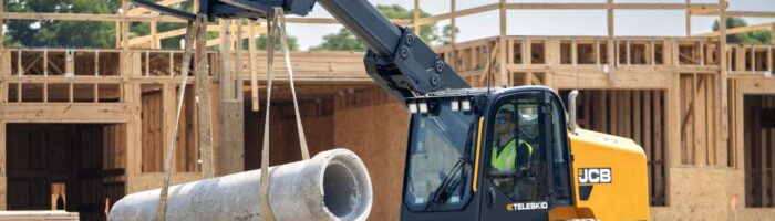 JCB 4TS Teleckid track loader holding up a piece of concrete pipe