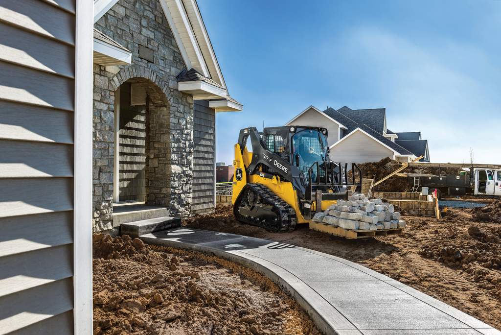 John Deere 317 P-Tier compact track loader near a house home