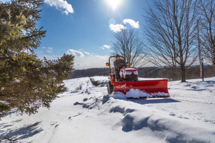 Massey Ferguson MF25 tractor in the snow with a snow blade attachment 