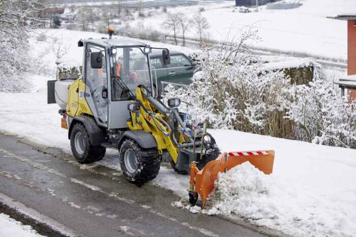 Wacker Neuson small articulated loader pushing snow with blade attachment