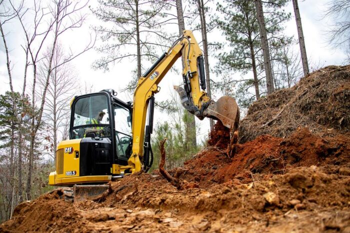 Caterpillar 303.5 mini excavator digging in the dirt