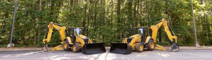 Caterpillar 440 and 450 Backhoe Loaders sitting in parking lot