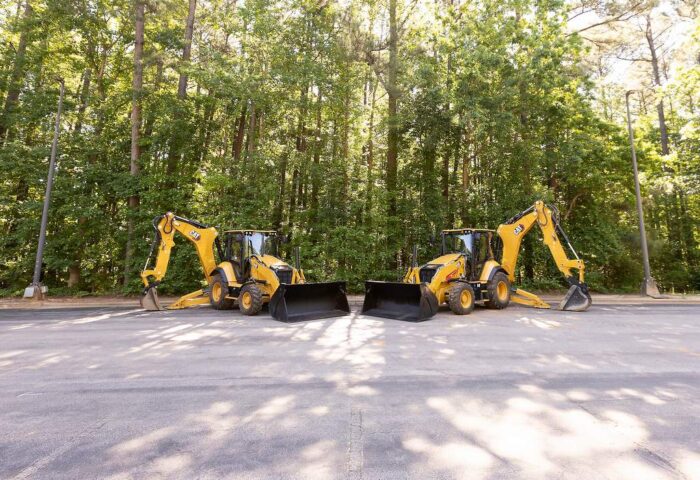 Caterpillar 440 and 450 Backhoe Loaders sitting in parking lot