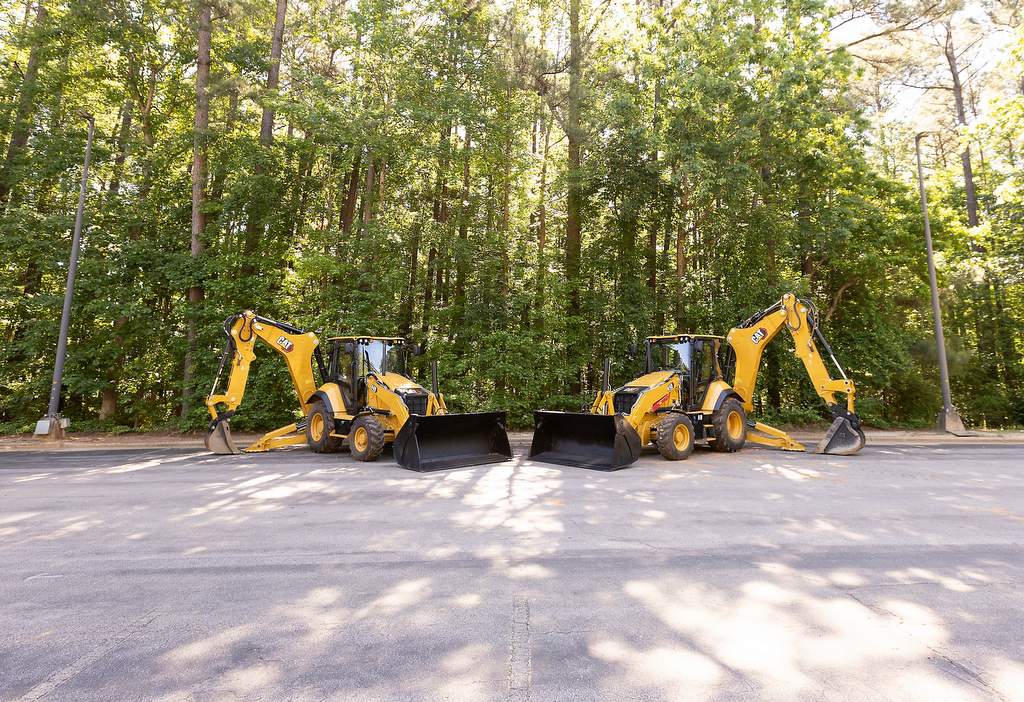 Caterpillar 440 and 450 Backhoe Loaders sitting in parking lot