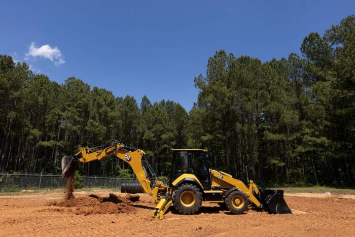 Caterpillar 450 Backhoe Loaders digging in the dirt