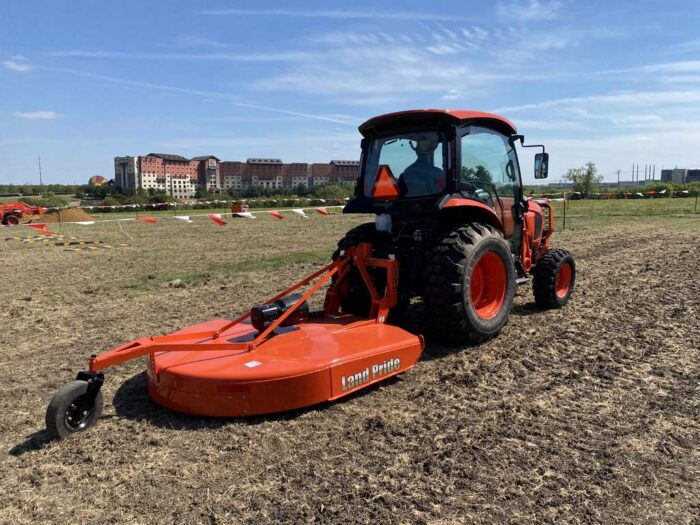 Kubota Grand L Series tractors mowing dirt 