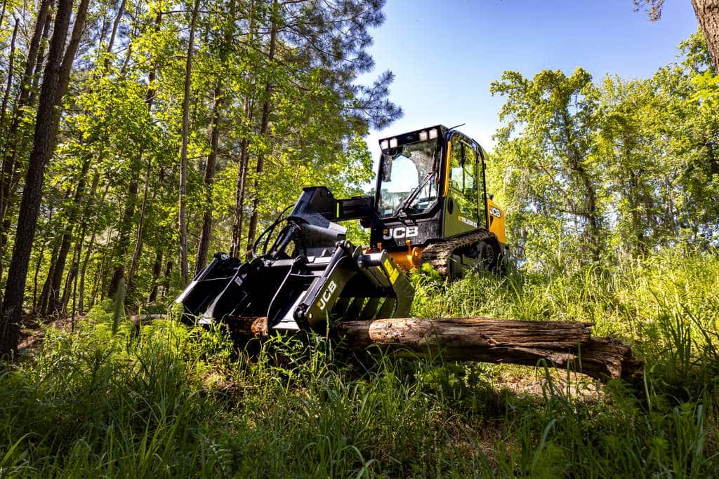 JCB 2TS-7T compact track loader with a grapple attachment working in a forest