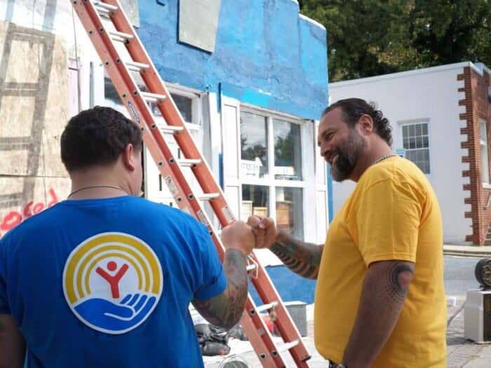 United Way men around a ladder United Way shirt on one of 'em