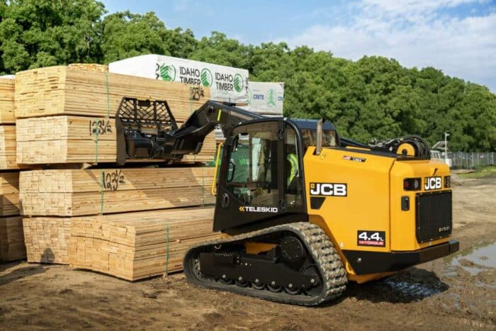 JCB 4TS Teleckid brush using a pallet fork attachment to lift lumber