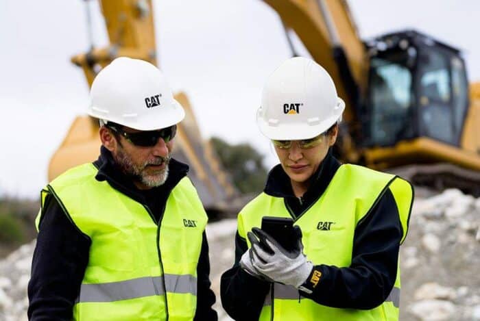 Caterpillar Phone two construction workers and an excavator in the background