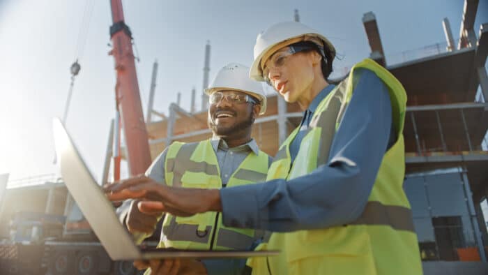 two contractors looking at a laptop